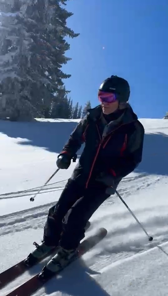 Skier carving a turn on a sunny mountain run